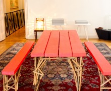 ein Esstisch mit 2 Bänken aus neon-rot gesprühten Holzbohlen